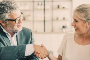 young female entrepreneur shake hands with a mature businessman