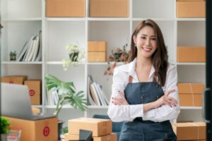young female entrepreneur in apron smiling and looking at the camera